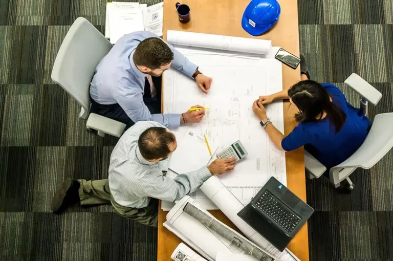 Réunion d'architectes autour d'un plan de chantier